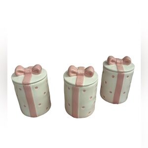 A set of small canisters white with a pink bow